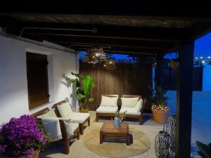 洪達海灘的住宿－Vivienda vacacional Ladera Kalblanke junto Cabo de Palos 6 personas，庭院配有白色椅子和吊灯。