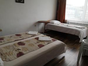 a room with two beds and a table and a window at Rooms Zora in Primorsko +10 photos