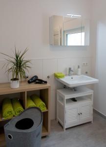 La salle de bains est pourvue d'un lavabo et d'un miroir. dans l'établissement Ferienwohnung ganz nah am Förderturm Zeche Zollverein, à Essen