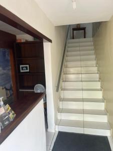 una escalera en una casa con escaleras blancas en Sol & Mar Pousada e Hospedaria, en Trancoso