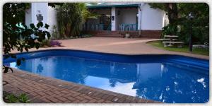 una piscina azul frente a una casa en House Ebony B&B, en Newcastle