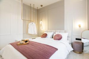 Un dormitorio con una gran cama blanca y una bandeja. en Annecy, en Alexandroupoli