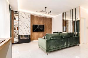 a living room with a green couch and a fireplace at Annecy in Alexandroupoli