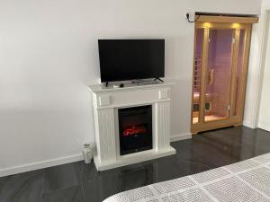 a white fireplace with a television on top of it at Studio apartman Valentina in Velika Mlaka