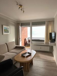 a living room with a couch and a table at Strandhotel in Wyk auf Föhr