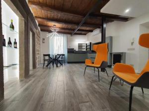 een woonkamer met houten vloeren en oranje stoelen bij SDL luxury home Al Pavone in Viterbo