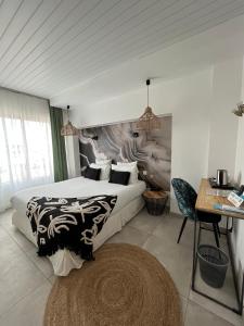 a bedroom with two beds and a table and a desk at Hôtel Les Sables - Urban Style - by Logis Hotels in Canet-en-Roussillon