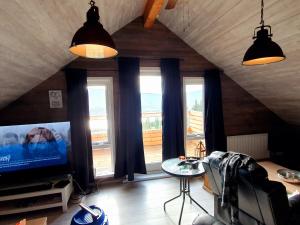 a living room with a tv and a large window at Akureyri Loghouse in Akureyri