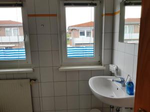 a bathroom with a sink and two windows at Ferienwohnung 110 im Haus Katharina mit großer Dachterrrasse in Lauterbach