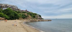 ein Strand mit Menschen im Sand und im Wasser in der Unterkunft Two room apartment in Etara 3, Sveti Vlas in Sweti Wlas