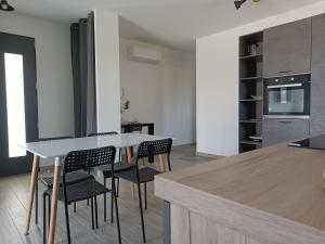 a kitchen with a table and chairs in a room at La p'tite des Got in Viriat