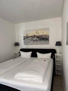 a bedroom with a large white bed with two lamps at Strandhotel in Wyk auf Föhr +34 photos