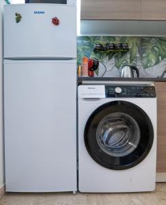 パレルモにあるSweet Homeの白い冷蔵庫、洗濯機付きのキッチンが備わります。