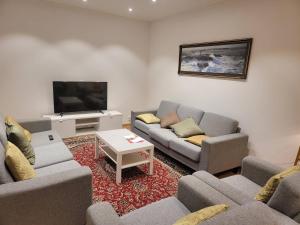 uma sala de estar com sofás e uma televisão de ecrã plano em 2 bed room Quite and central house in Orebro em Örebro