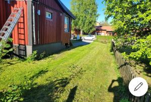 un patio junto a una casa roja con un cartel en 2 bed room Quite and central house in Orebro, en Örebro