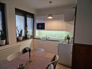 a kitchen with a table and a table and chairs at Börzsöny Vendégház in Zebegény