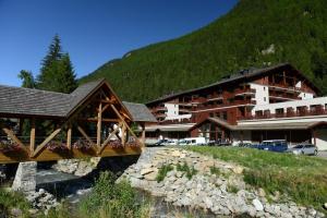 un edificio con un puente frente a una montaña en Le calme, le confort, la nature, skis aux pieds, à 15 kilomètres de Chamonix, en Vallorcine