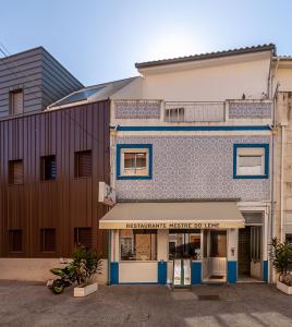 un magasin devant un bâtiment avec des carreaux bleus et blancs dans l'établissement Arrochela by Home Sweet Home Aveiro, à Aveiro