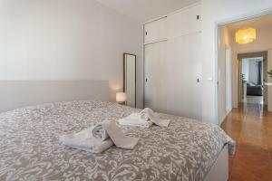 1 dormitorio con 1 cama grande y toallas. en Arrochela by Home Sweet Home Aveiro, en Aveiro