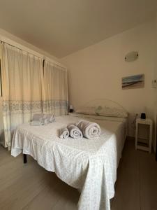 1 dormitorio con 1 cama con toallas en Studio's Pavese, en Olbia