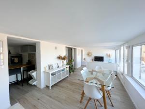 una sala de estar blanca con mesa y sillas en Dépendance T3 proches des plages en Lattes