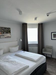Habitación de hotel con cama y ventana en Strandhotel, en Wyk auf Föhr