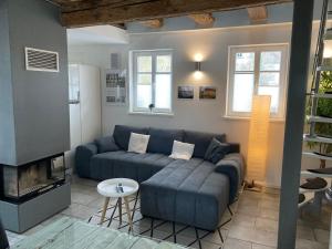 ein Wohnzimmer mit einem blauen Sofa und einem Kamin in der Unterkunft Ferienhaus Hassgautor in Aidhausen