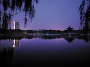 Shangri-La Huhhot في هوهوت: اطلالة على بحيرة في الليل مع مبنى صيني