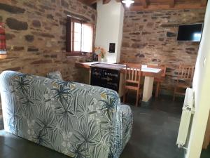 a living room with a couch and a table at O Busto Aldea Rural, Apartamento HORNO 2 in A Pobra do Brollon
