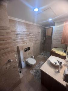 y baño con aseo, ducha y lavamanos. en Luxery suite GOLDCITY GOLD CITY Alanya en Alanya