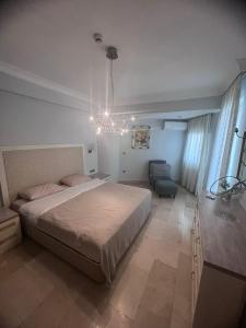 Un dormitorio con una cama grande y una lámpara de araña. en Luxery suite GOLDCITY GOLD CITY Alanya, en Alanya