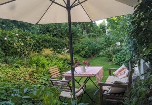 un tavolo e sedie con ombrellone in giardino di Stylisches Villa-Apartment in Schlossgartennähe a Schwerin