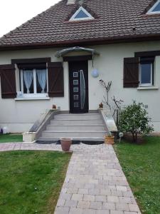 a white house with a black door and stairs at Leira 