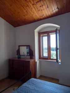 1 dormitorio con cama, espejo y ventana en Scicli Città felice, en Scicli