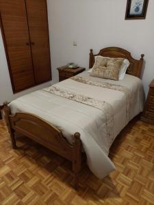 a bed in a bedroom with a wooden floor at Residencial Real - Antiga Rosas in Vila Real