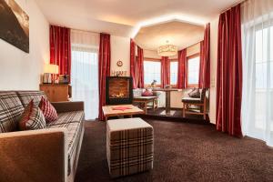 a living room with a couch and a fireplace at Ferienhotel Jörglerhof in Hainzenberg
