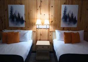 two beds in a room with two lamps on the wall at Cliff Dweller on Lake Superior in Tofte