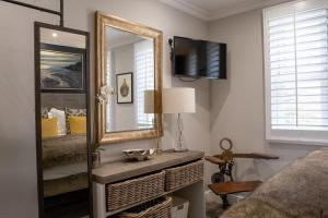 ein Schlafzimmer mit einem Spiegel, einem Bett und einem TV in der Unterkunft Marners Rock No 3 in Fowey