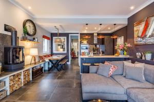 ein Wohnzimmer mit Couch und Küche in der Unterkunft Marners Rock No 3 in Fowey