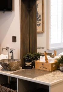eine Badezimmertheke mit einem Waschbecken und einer Arbeitsplatte mit einer Schachtel darauf in der Unterkunft Marners Rock No 3 in Fowey + 50 Fotos
