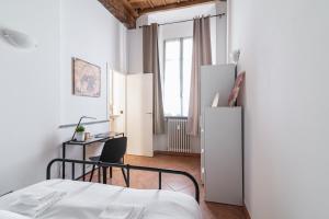 une chambre avec un lit, un bureau et une chaise dans l'établissement House of Foscolo - Palazzo Cornazzani - by Host4U, à Pavia