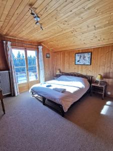 a bedroom with a large bed in a wooden room at Chalet traditionnel avec jacuzzi extérieur in Bex