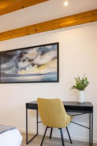 a desk with a chair and a painting on the wall at Stadtmauer-Apartments - Stilvolle Wohnung mit King Bett direkt an der historischen Stadtmauer in Nördlingen