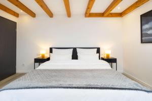 a bedroom with a large white bed with two lamps at Stadtmauer-Apartments - Stilvolle Wohnung mit King Bett direkt an der historischen Stadtmauer in Nördlingen