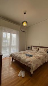 a bedroom with a large bed with two shoes on the floor at JR apartments in Athens