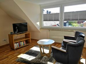 ein Wohnzimmer mit einem Stuhl und einem TV in der Unterkunft Haus Elisa in Helgoland