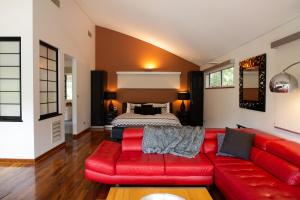 a red couch in a living room with a bed at Silkwood Estate in Pemberton