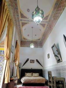 1 dormitorio con cama y lámpara de araña en Riad Freija-TAROUDANT, en Sidi Abd el Kader