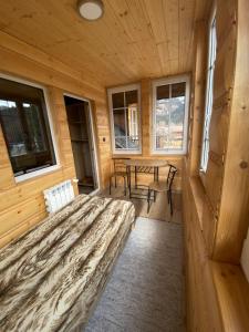 a bedroom in a log cabin with a bed and windows at U Hudoka in Sromowce Niżne