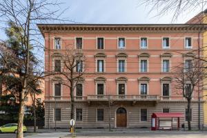 a large pink building with a red canopy in front of it at Italy Prestigious Guest House in Bologna